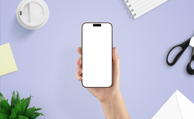 Wall Mural - top view of female hand holding smartphone over creative desk. ideal mockup for showcasing mobile ap