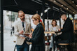 © qunica.com - Two business professionals engage in a conversation outdoors in a modern cafe setting, emphasizing collaboration and entrepreneurship.
