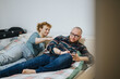 © qunica.com - A casual scene of a cheerful couple lounging comfortably on their bed in a cozy environment, sharing a moment of relaxation, conversation, and connection, exemplifying modern lifestyle and domestic