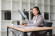 © jojo - A young female employee searches for documents on her desk in an office.
