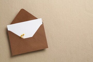 Wall Mural - Blank invitation card with flowers and envelope on carton, top view. Space for text