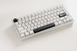 Modern mechanical keyboard on white desk as background. Minimal style and design keyboard. Custom build keyboard with black and white cap. Close up