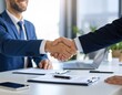 © KALOKI - Accord professionnel entre deux collègues dans un bureau moderne – poignée de main et contrat signé