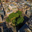 © Alexey Fedorenko - Aerial view of Hanover Square in London featuring green park space, surrounding classic architecture, and city streets on a clear day.