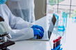 © aFotostock - Scientist man using laptop typing computer keyboard in chemical testing science laboratory. Doctor clinic biochemistry lab technician diagnosis technology. Asian man scientist working laptop medical