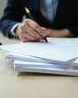 © Елена Сайкина - Business professional filling out forms with a black pen on a stack of documents