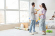 © Pixel-Shot - Young pregnant couple with paint roller during repair in children's room