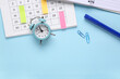 © Pixel-Shot - Calendar with alarm clock and stationery on blue background with space for text