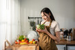 © Kawee - Asian young woman cooking healthy foods in kitchen in morning at home.