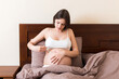 © sosiukin - Pregnant woman with insulin syringe in home on bed. Pregnant diabetes concept