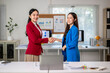 © Wasana - Two businesswomen shaking hands after closing a business deal in the office