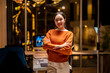 © Wasana - Young asia businesswoman standing with arms crossed and smiling in modern office at night