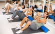 © JackF - Group of different people performs sports exercises in fitness center