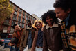 © bernardbodo - Group of happy multiracial friends walking and having fun in Madrid, Spain