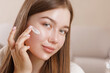 © st.kolesnikov - Young Woman Applying Moisturizing Face Cream for Skin Care and Beauty Routine at Home
