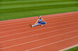 © Yevhen - Female runner stretching before workout. Sports exercises and stretching in the stadium. Physical training girl. Fit girl do outward lunging