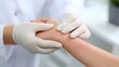 © Kannika - Test for Atopic dermatitis. Medical professional examining a patient's arm with skin condition in a clinical setting.