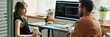 © Mediaphotos - Caucasian young adult woman discussing neural network development with Caucasian middle aged man sitting at desk, computer monitor displaying code related to artificial intelligence project