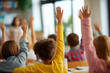 © tynza - Group of diverse elementary school children raising hands during a lesson in a bright classroom.