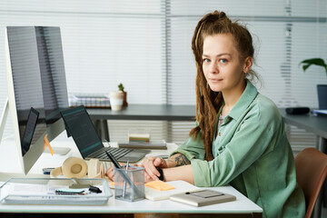 portrait of caucasian young adult woman sitting at desk working on neural network development using 