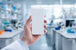 © Руслан Галиуллин - scientist's hand with white smartphone screen in laboratory, mock up, copy space, analysis results