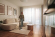 © Big Shot Theory - A woman vacuums in a bright, modern living room filled with natural light