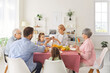© Studio Romantic - Happy big family of different generations sitting around table, sharing and passing dishes from hand to hand. Parents, grandparents and children having lunch at dining room, enjoying meal together.