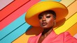 © svastix - A stunning model showcases a vibrant yellow hat and pink suit against a colorful background, highlighting bold fashion choices and creative expression in contemporary style.