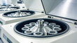 © Kittinan - Close up view of laboratory centrifuge with open lids, showcasing metal rotor and sample holders, used for scientific research and analysis