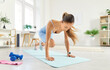 © Studio Romantic - Strong sporty athletic young woman performing mountain climber exercise in plank pose on exercise mat, running in emphasis lying down, doing intense workout in living room at home. Healthy lifestyle.