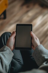 Hands holding a tablet in front of the user.