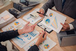 © ThawKyar - Business team discuss and explain marketing plan to plan financial strategy for business owner using laptop, calculator, chart sheet to calculate and summarize results. Business and finance concept.