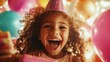 © svastix - A young girl wearing a party hat expresses pure joy while surrounded by colorful balloons and presents, capturing the essence of childhood happiness during a birthday celebration.