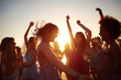 © mattegg - People are dancing joyfully at a vibrant outdoor sunset party