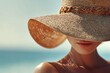 © Lyashko-Ai - A beautiful woman wearing a stylish straw hat under the summer sun.