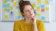 © Zaheer - A thoughtful young woman in a yellow sweater stands in front of a whiteboard cluttered with various sticky notes Her
