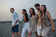 © bernardbodo - Group of people walking on a sandy beach