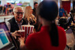 © bernardbodo - Senior man purchasing popcorn and beverage in theater.