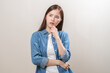 © KMPZZZ - Portrait of face expression stress, asian young woman, confused girl standing pose looking camera in casual. unhappy female thinking creative, thinks about problem, isolated on background, copy space.