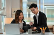 © saltdium - Two business coworkers are discussing ideas and reviewing a clipboard, Teamwork and Discussion in Workspace