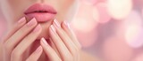 The elegant lips and perfectly manicured nails in soft pink tones.