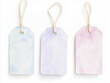 © Atlantis - Three pastel colored blank gift tags hanging on white background