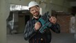 © Yuliia - Man building industry repairman builder holding hammer drill repair work construction renovation male engineer handyman foreman engineer architect electrician demonstrate drilling instrument guy smile