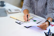 © Prathankarnpap - Man reviewing financial documents at modern office desk