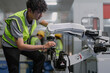 © Nassorn - Robot maintenance engineer working on robot arm connection. Young adult man learning training robotic machine engineering in futuristic electronic education academy. Artificial intelligence technician