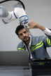 © Nassorn - Latino robotic development engineer working robot arm connection control at electronic futuristic science laboratory. Hispanic technician learning innovation machine in automated engineering academy.
