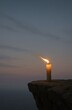 © Suraaj - Lone Candle Flickering in Wind on Cliff Edge at Twilight, Symbol of Hope, Solitude, and Resilience
