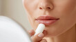 © OHMAl2T - Applying lip balm for smooth lips beauty routine indoor close-up self-care