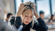 © qingqing - A student's anxious expression captured in a classroom setting with soft natural light highlighting their face.