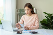 © Pormezz - Deduction planning, debt asian young woman  hand using calculator to calculating money balance from bill and income, cost budget expenses for pay money form personal individual on table at home.